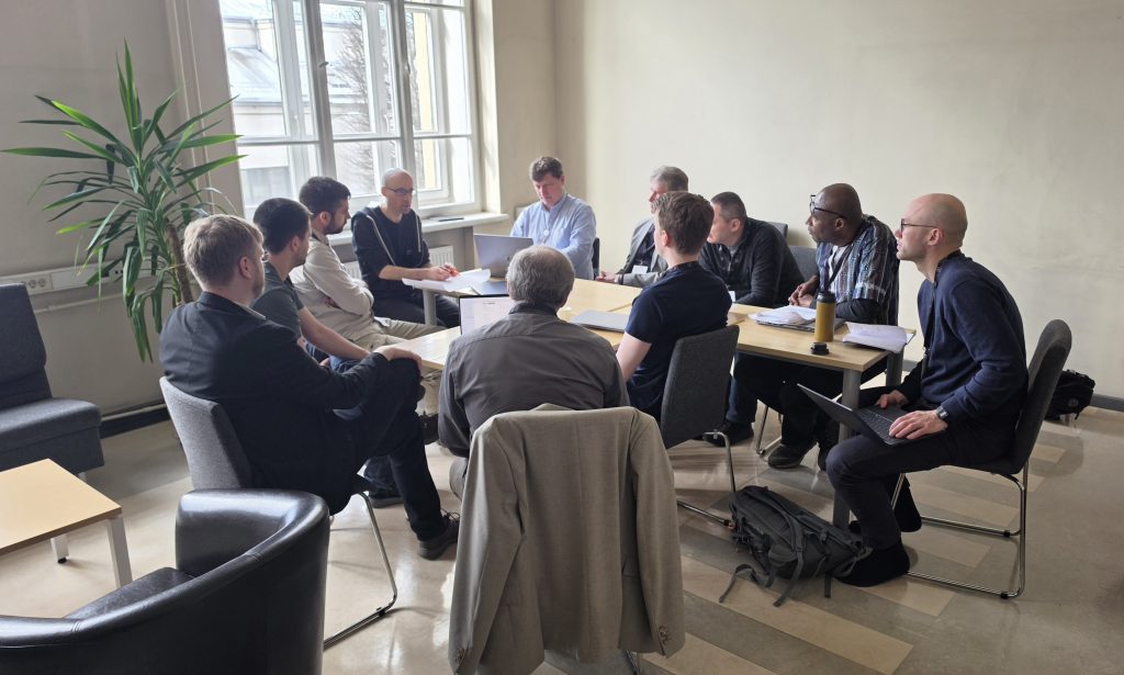 Žmonės susėdę aplink stalą